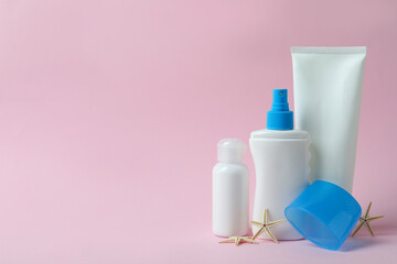 Blank sunscreens and starfishes on pink background