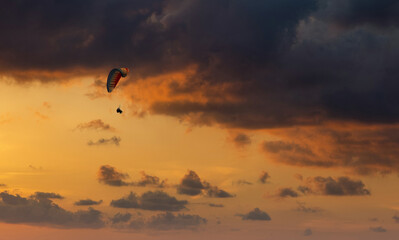 Fototapeta na wymiar Paraglider flying in the beautiful sky against the background of clouds.