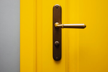 Close-up shot of yellow color door with vintage door knob. - obrazy, fototapety, plakaty