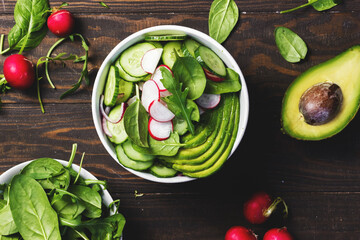 Health vegetarian salad with avocado, radish, spinach and cucumber