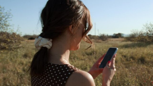 Giovane ragazza si fa le foto in campagna con il telefonino