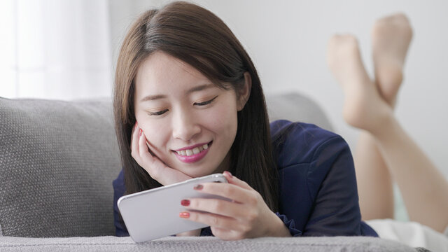 スマホで動画鑑賞・ゲームをする女性