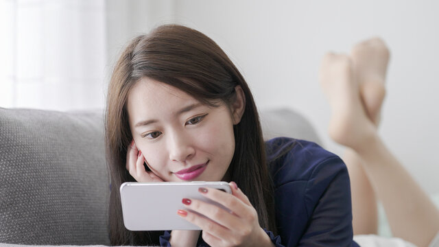 スマホで動画鑑賞・ゲームをする女性