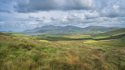 Fototapeta na wymiar Beautiful valley with green fields, farms, forest and lake, surrounded by hills and mountains, Dingle Peninsula, Wild Atlantic Way, Kerry, Ireland