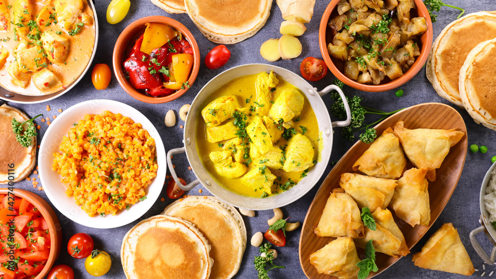 Poster indian food assortment- naan, curry chicken, samosa, dhal lentils