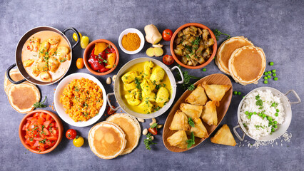 indian food assortment- naan, curry chicken, samosa, dhal lentils