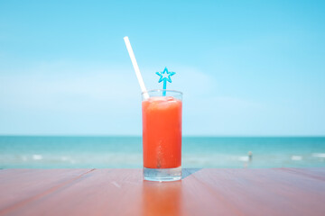 Fruit cocktail summer drink on vacation with blur beach on background
