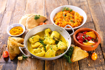 assorted indian food - naan, curry chicken, dhal lentil and rice