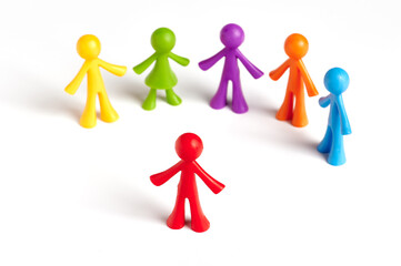 . Toy people Isolated on white background. The red man stands apart from the group. Asociality,...