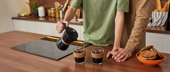 Young same sex male pair hugging in light kitchen
