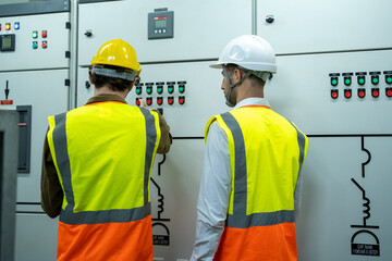 Technical worker with engineer working and checking in control room power plant at industry factory.