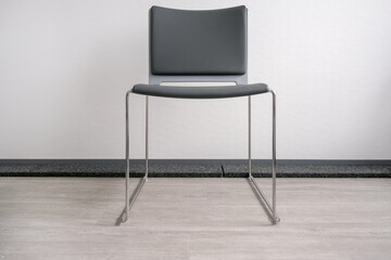 Konzept Warten: Ein leerer Stuhl in einem modernen Wartezimmer oder Wartebereich - selektiver...