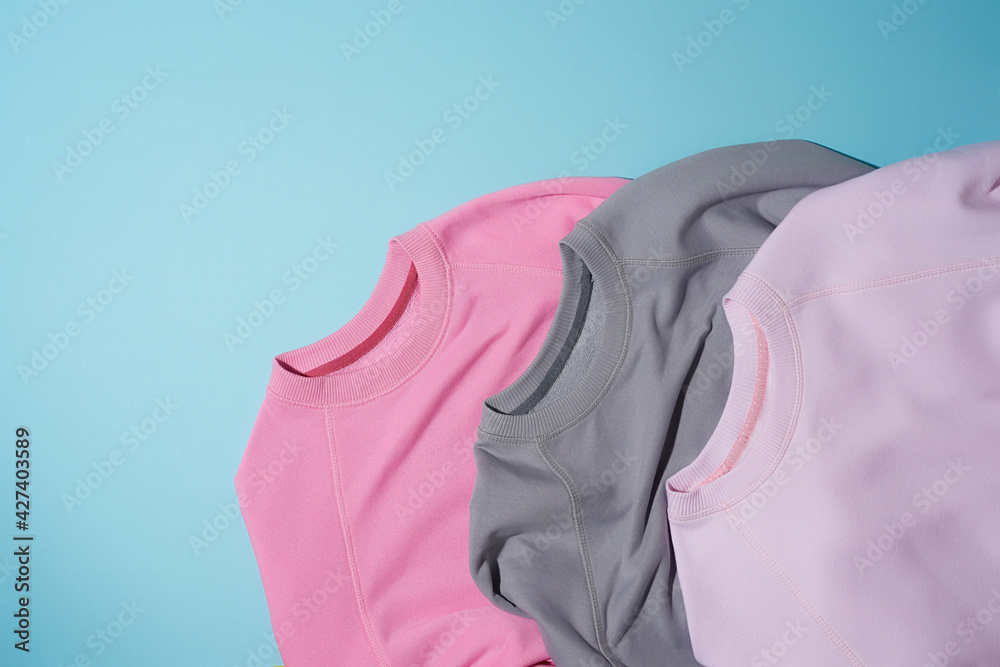 Wall mural Top view of gray and pale pink pastel sport blank sweatshirts isolated on light blue background