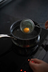 Break an egg into a strainer and cook poached