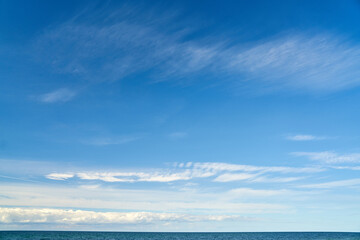 Naklejka na ściany i meble Blue sky with clouds over horizon of ocean