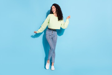 Photo of dreamy flirty lady have fun dance look empty space wear sweater jeans footwear isolated blue background