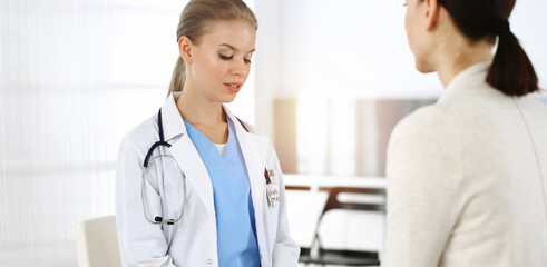 Obraz premium Woman - doctor consults her female patient in sunny clinic