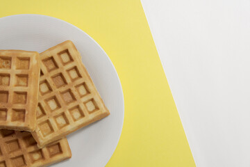 Homemade waffles, top view. on a yellow and white background