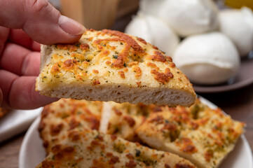 Tasty italian vegetarian food, fresh baked flat foccachia bread with white mozzarella cheese and herbs