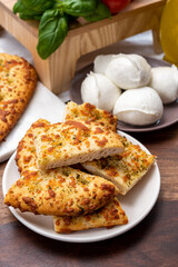 Tasty italian vegetarian food, fresh baked flat foccachia bread with white mozzarella cheese and herbs