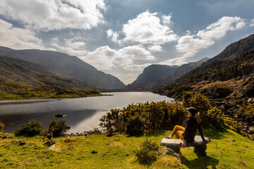 female cyclist admiring mountainous scenery at Gap of Dunloe kerry mountains