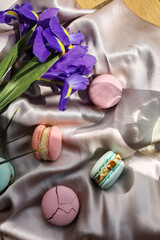 colorful delicious homemade traditional french macarons - elegant french dessert. Natural fruit and berry flavors, creamy stuffing and blue iris flowers on cloth for valentines mother day easter