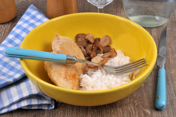 Escalope de poulet avec du riz et des champignons servis dans une assiette