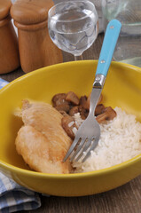 Escalope de poulet avec du riz et des champignons servis dans une assiette