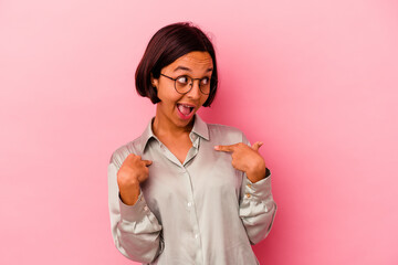 Young mixed race woman isolated on pink background surprised pointing with finger, smiling broadly.