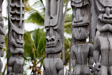 wooden carved tiki with palm trees in the back