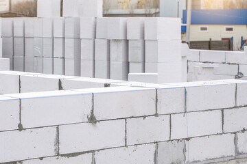 Construction of Aerated Concrete. Unfinished house wall made from white aerated autoclaved concrete blocks