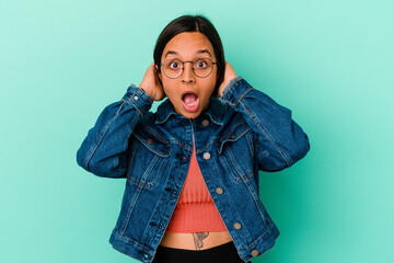 Fototapeta na wymiar Young mixed race woman isolated on blue background screaming, very excited, passionate, satisfied with something.