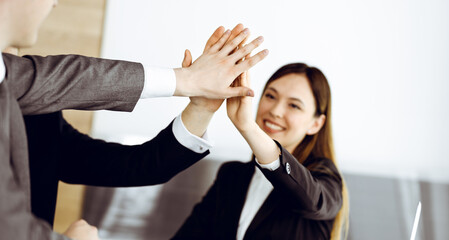 Unknown business people group joining hands in modern office. Businessmen and women making circle with their hands as a team, close-up