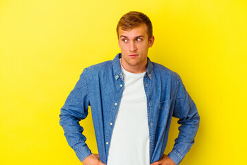 Young caucasian man isolated on yellow background