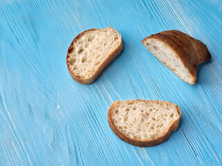 three slices of rustic home made bread on a blue table