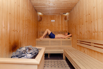 handsome Middle aged man lying in finland sauna. relaxation and rest concept