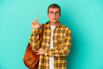 Young caucasian student man isolated on blue background