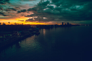 Panorama Cityscape at sunset with large river at foreground and strom clouds at background in...