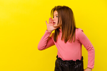 Little caucasian girl isolated on yellow background is saying a secret hot braking news and looking...
