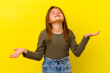Little caucasian girl isolated on yellow background relaxed and happy laughing, neck stretched...