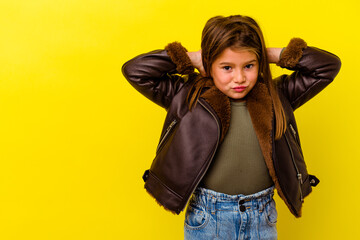 Little caucasian girl isolated on yellow background touching back of head, thinking and making a...
