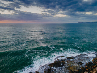 Aerial sunrise seascape with waves and clouds