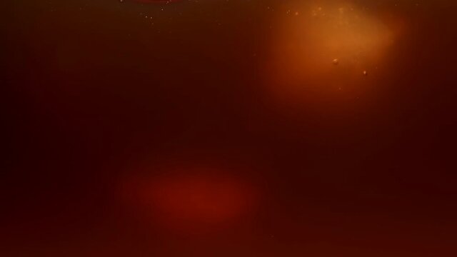 Immersion, drop of ice cubes into coffee with milk, tea. Splashes, waves, bubbles of the drink. The process of preparing a cool drink. Slow motion. Close up.