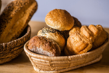 Bread rolls and croissant lying in basket on table