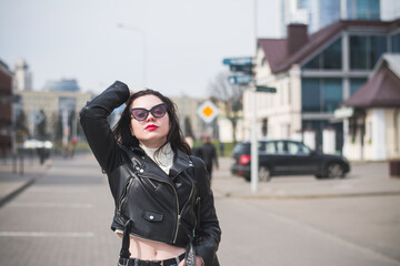 Obraz premium A beautiful hipster girl with a phone in her hands walks down the street