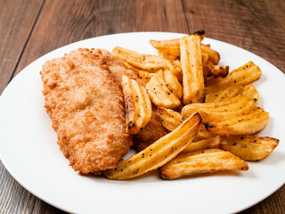 Traditional fish and chips dish on white plate. Common take away meal in English speaking nations....