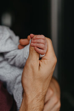 home photos of a newborn baby in the arms of one parent
