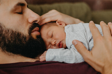 home photos of a newborn baby in the arms of father. Selective focus, noise effect