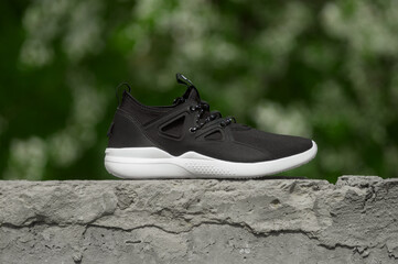 Black sneakers with white sole in the city background