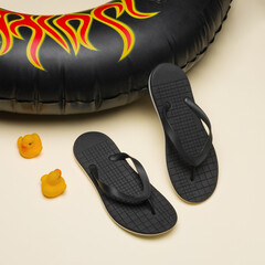 Black slippers with Beach lifebuoy on yellow background